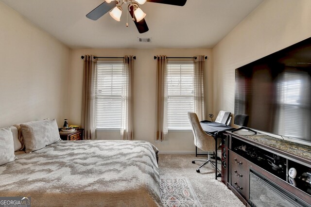 bedroom with visible vents, a ceiling fan, baseboards, and light colored carpet