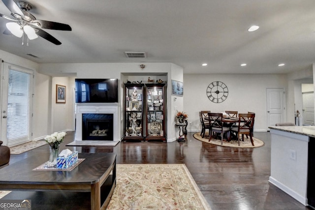 living area with visible vents, recessed lighting, baseboards, and wood finished floors