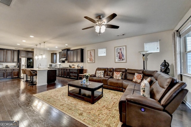 bedroom with a ceiling fan, visible vents, wood finished floors, a raised ceiling, and baseboards