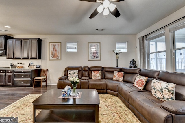 living room featuring baseboards, ceiling fan, visible vents, and dark wood-type flooring