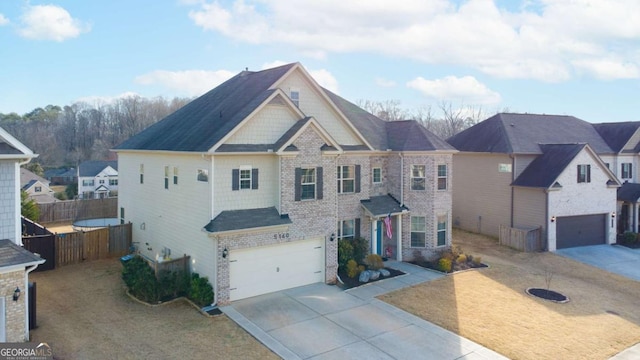 view of front of house with an attached garage, concrete driveway, a front yard, and fence