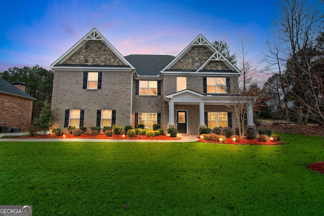 view of front facade with a front lawn, cooling unit, and brick siding