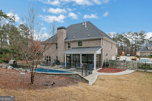 back of house featuring a fenced in pool, a patio, a sunroom, fence, and brick siding