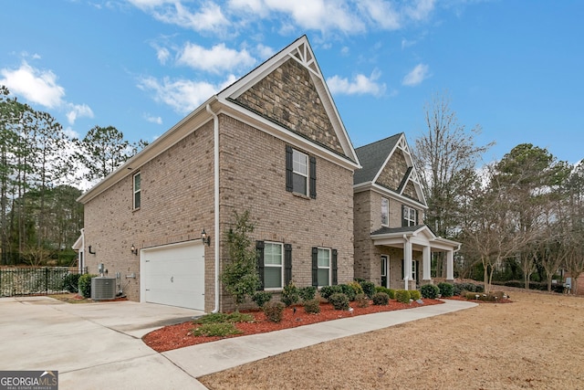 view of home's exterior featuring a garage, concrete driveway, fence, central AC, and brick siding