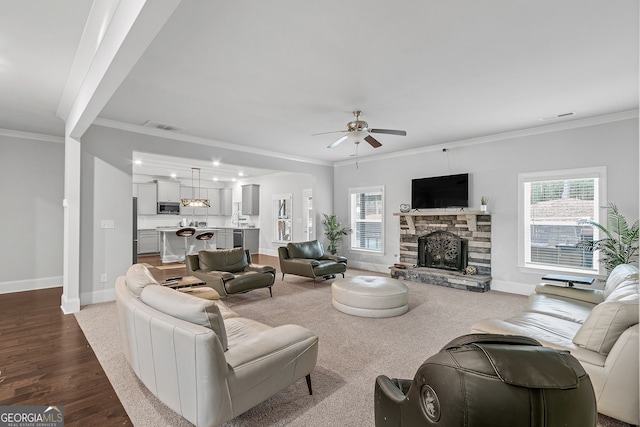 living area featuring visible vents, ornamental molding, and a wealth of natural light