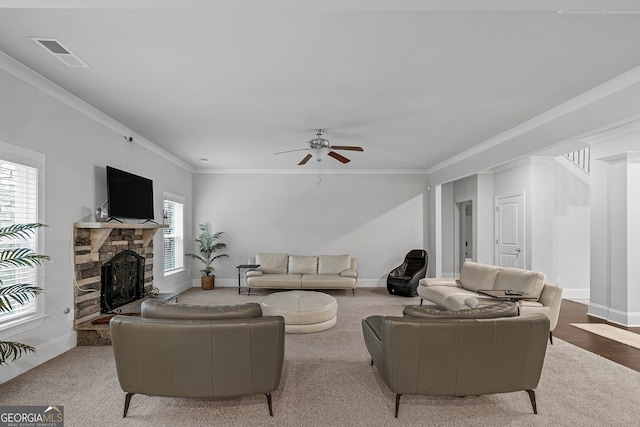 living room featuring baseboards, a fireplace, visible vents, and ornamental molding