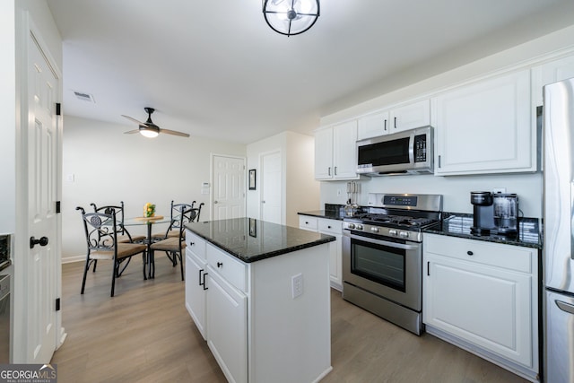 kitchen with stainless steel appliances, light wood-type flooring, white cabinets, and visible vents