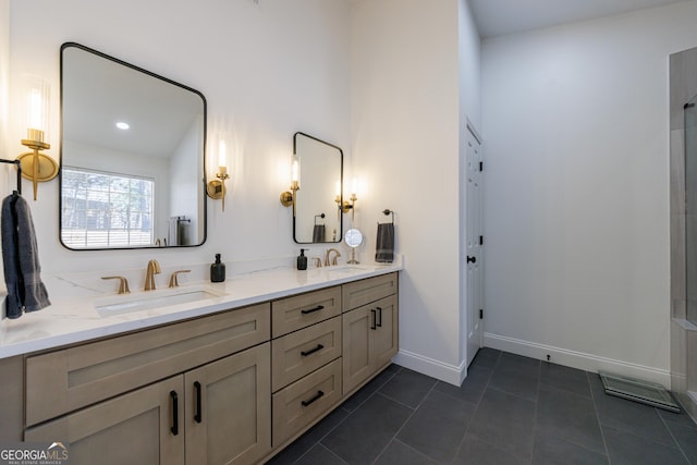 full bath with double vanity, a sink, baseboards, and tile patterned floors