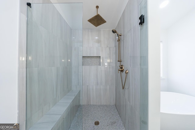 bathroom featuring a freestanding bath and tiled shower