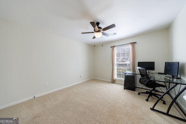 office space featuring light carpet, a ceiling fan, visible vents, and baseboards