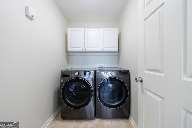 laundry room featuring washer and dryer, cabinet space, and baseboards