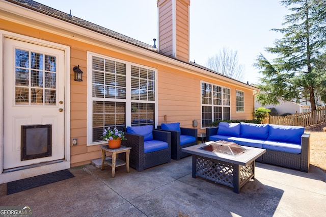 view of patio with fence and an outdoor living space with a fire pit