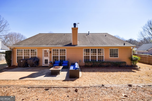 back of house with an outdoor living space with a fire pit, a chimney, a shingled roof, a patio area, and fence