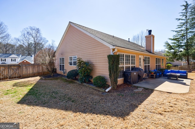 view of property exterior featuring a patio area, a chimney, fence, and an outdoor living space