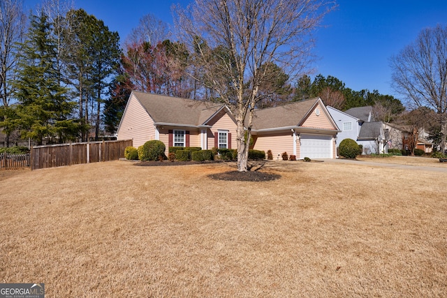 ranch-style house featuring driveway, a garage, fence, and a front lawn