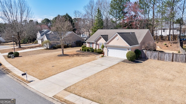 view of front of property with a garage, roof with shingles, driveway, and fence