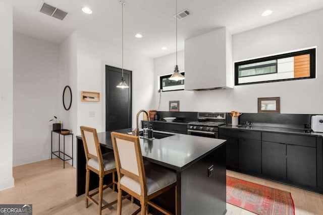 kitchen with dark countertops, stainless steel range oven, visible vents, and dark cabinetry