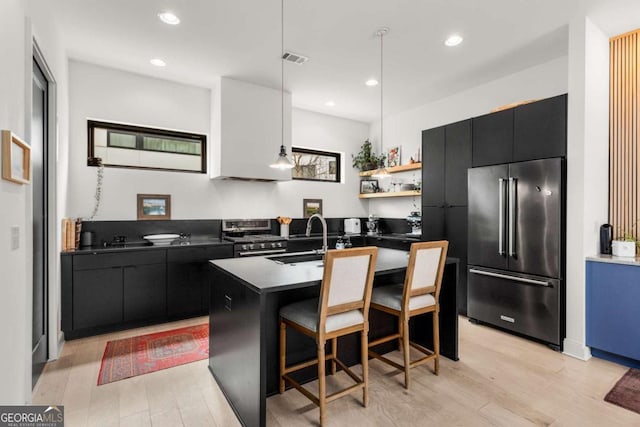 kitchen with stainless steel appliances, dark cabinetry, dark countertops, and visible vents