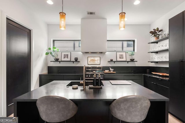 kitchen featuring open shelves, dark countertops, and a sink