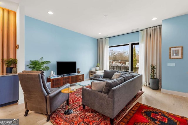 living area featuring visible vents, baseboards, wood finished floors, and recessed lighting