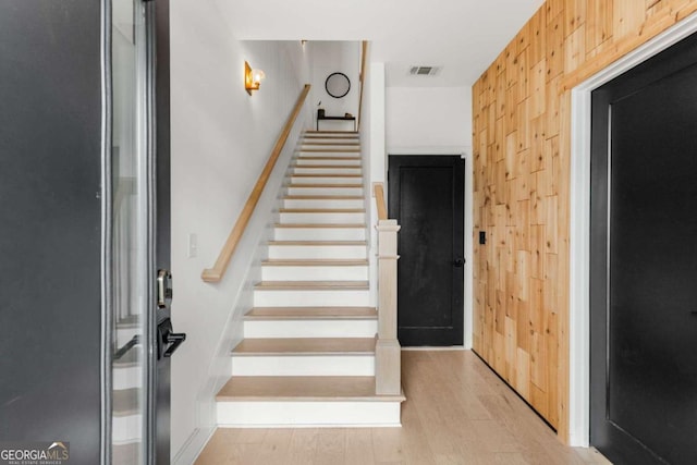 stairway with visible vents and wood finished floors