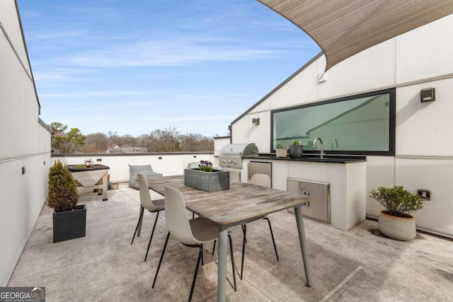 view of patio / terrace featuring outdoor dining area, a sink, and area for grilling