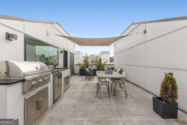 view of patio with a sink, outdoor dining space, an outdoor kitchen, and a grill