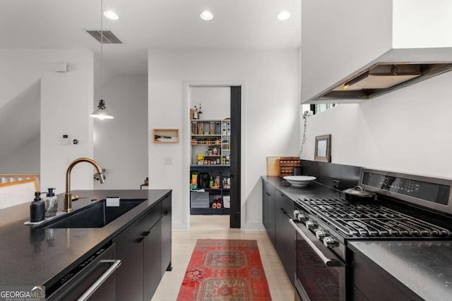 kitchen featuring dark countertops, visible vents, a sink, wall chimney range hood, and gas range