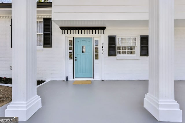 view of exterior entry featuring brick siding