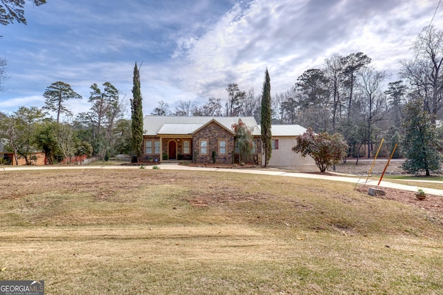 ranch-style house featuring metal roof and a front lawn