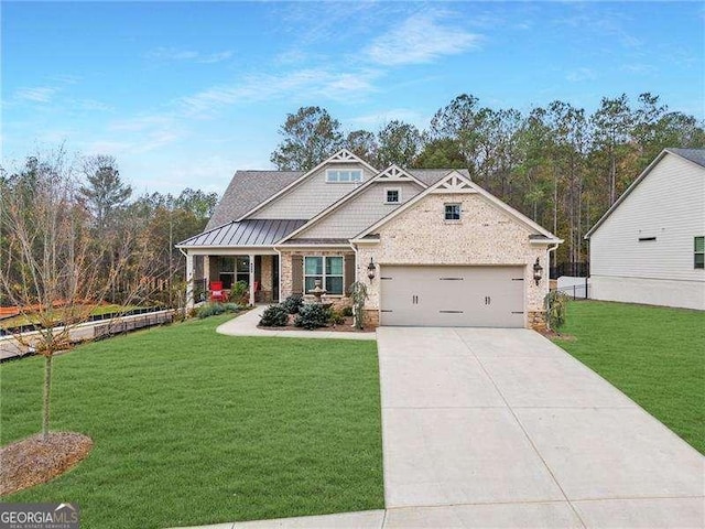 craftsman house featuring brick siding, a garage, concrete driveway, and a front yard