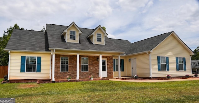 cape cod house with brick siding and a front yard