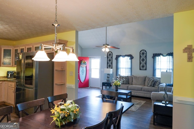 dining room with a textured ceiling, a ceiling fan, vaulted ceiling, and dark wood-type flooring