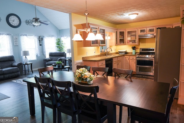 dining room with a textured ceiling, lofted ceiling, ceiling fan with notable chandelier, dark wood-style flooring, and visible vents