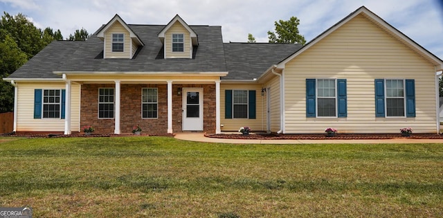 new england style home featuring brick siding and a front yard