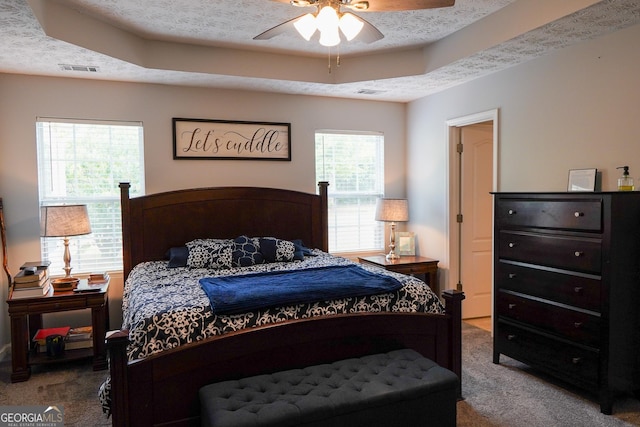 carpeted bedroom featuring a textured ceiling and visible vents