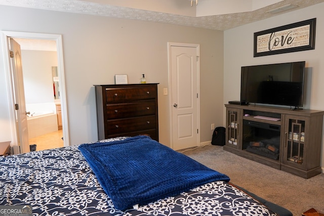 carpeted bedroom with visible vents and ensuite bathroom