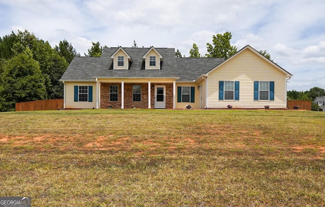 cape cod home with a front yard and fence