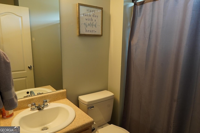 bathroom with a shower with shower curtain, vanity, and toilet