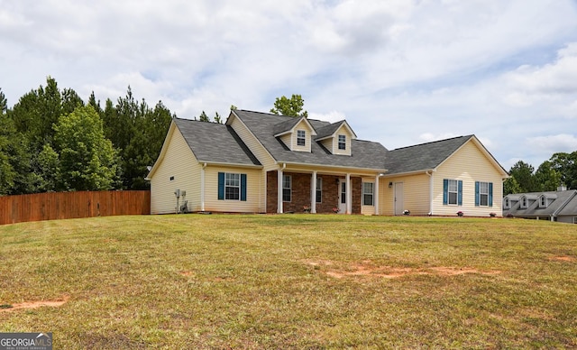 cape cod-style house with fence and a front lawn