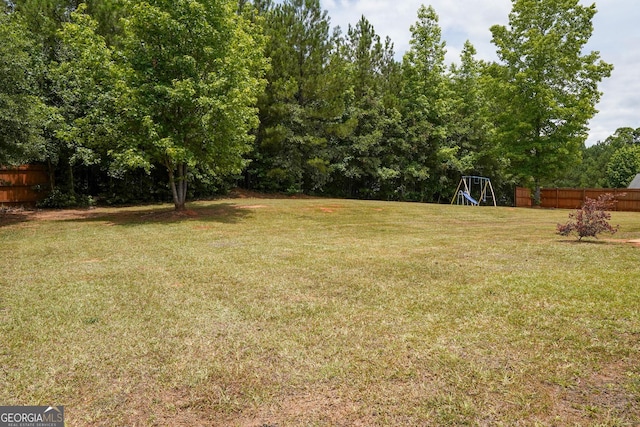 view of yard featuring a playground and fence