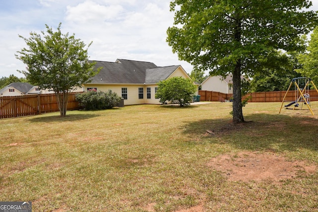 view of yard with a fenced backyard and a playground