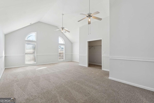 interior space featuring carpet floors, high vaulted ceiling, and baseboards