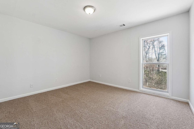 carpeted empty room with visible vents and baseboards