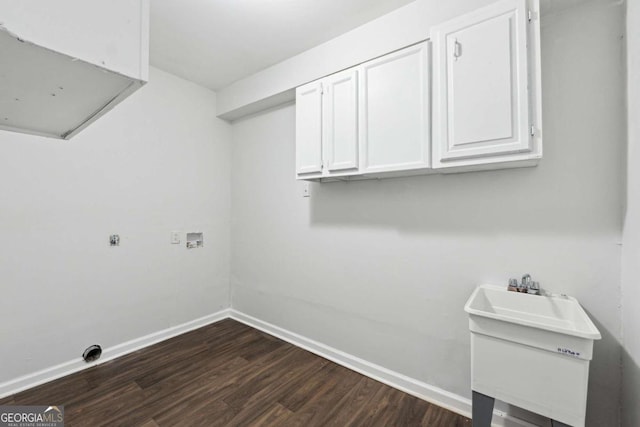 clothes washing area with dark wood-type flooring, cabinet space, hookup for a washing machine, and baseboards