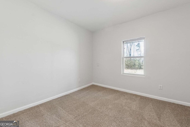 carpeted spare room with baseboards