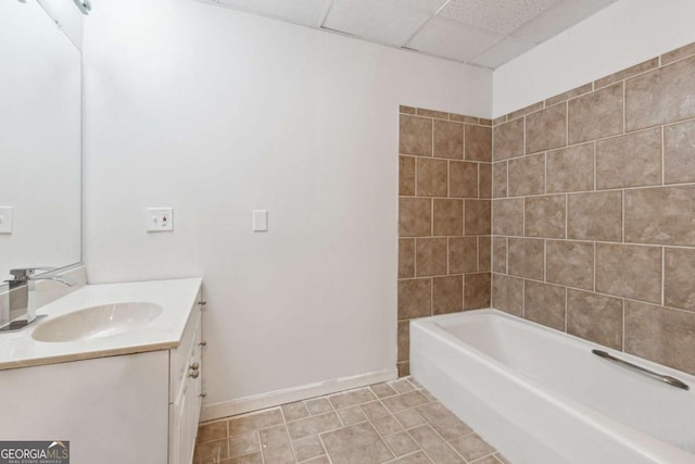 bathroom with shower / washtub combination, a paneled ceiling, vanity, baseboards, and tile patterned floors