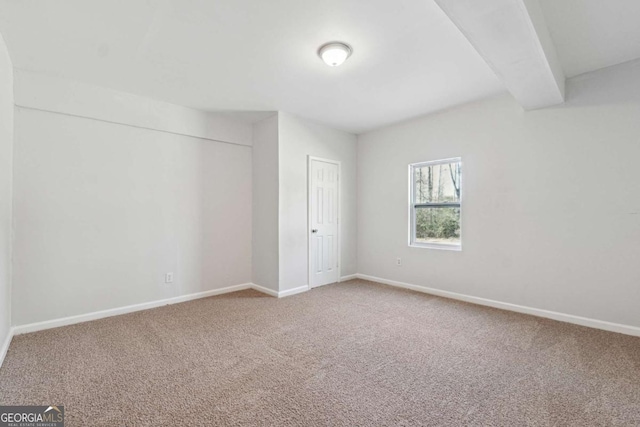 unfurnished bedroom featuring beam ceiling, a closet, baseboards, and carpet flooring