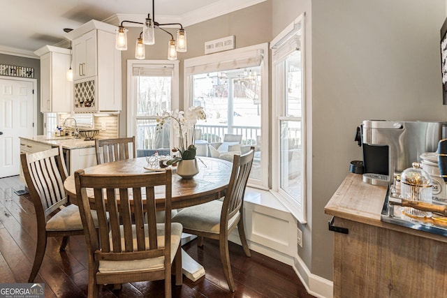 dining area with baseboards, dark wood-type flooring, and crown molding