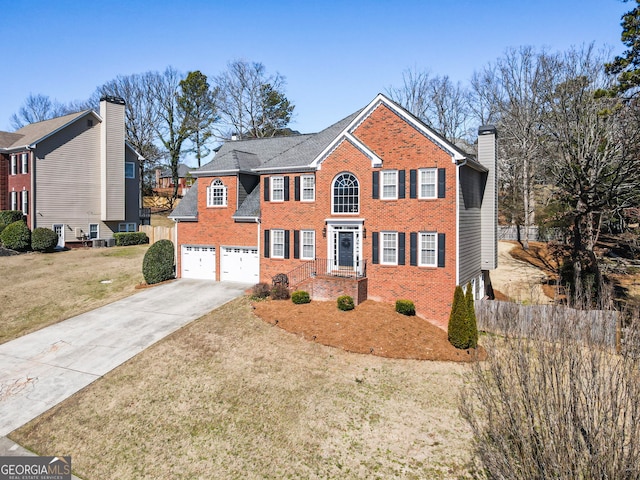 view of front of property with brick siding, a chimney, concrete driveway, a front yard, and a garage